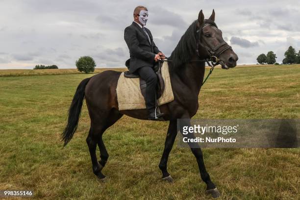 Man riding a horse wearing Guy Fawkes mask is seen in Grunwald, Poland on 13 July 2018 Battle of Grunwald reenactment participants take part in the...