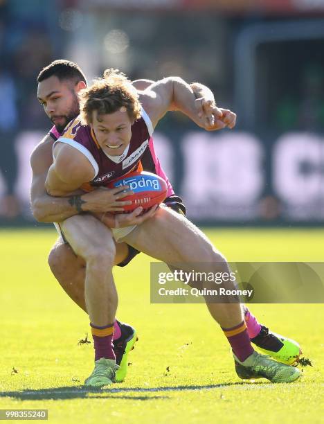 Ryan Lester of the Lions is tackled by Jarman Impey of the Hawks during the round 17 AFL match between the Hawthorn Hawks and the Brisbane Lions at...