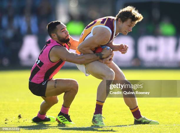 Ryan Lester of the Lions is tackled by Jarman Impey of the Hawks during the round 17 AFL match between the Hawthorn Hawks and the Brisbane Lions at...
