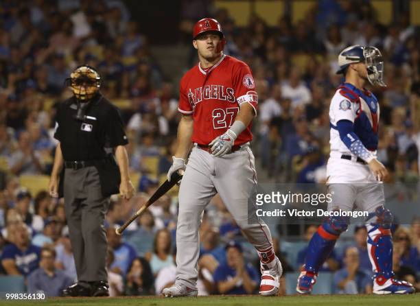 Mike Trout of the Los Angeles Angels of Anaheim walks back to the dugout after being called out on strikes by home plate umpire Larry Vanover as...
