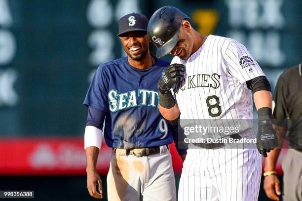 Gerardo Parra of the Colorado Rockies and Dee Gordon of the Seattle Mariners share a laugh at second base after Parra doubled in the second inning of...