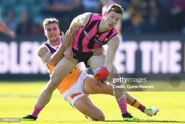 Tim O'Brien of the Hawks is tackled by Tom Cutler of the Lions during the round 17 AFL match between the Hawthorn Hawks and the Brisbane Lions at...