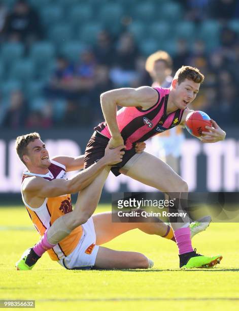 Tim O'Brien of the Hawks is tackled by Tom Cutler of the Lions during the round 17 AFL match between the Hawthorn Hawks and the Brisbane Lions at...