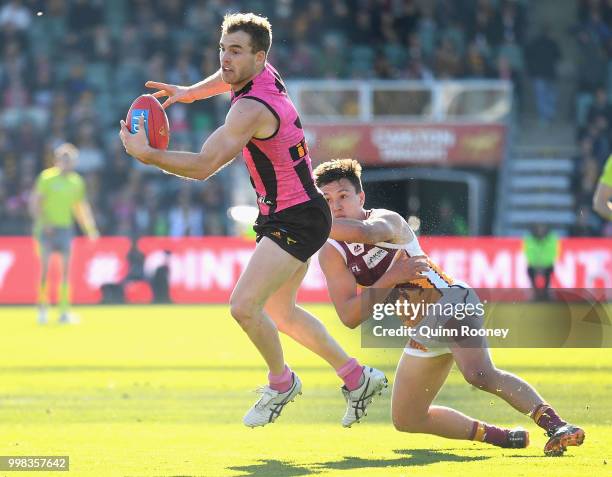 Tom Mitchell of the Hawks is tackled by Hugh McCluggage of the Lions during the round 17 AFL match between the Hawthorn Hawks and the Brisbane Lions...