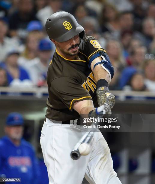 Austin Hedges of the San Diego Padres hits an RBI single during the eighth inning of a baseball game against the Chicago Cubs at PETCO Park on July...