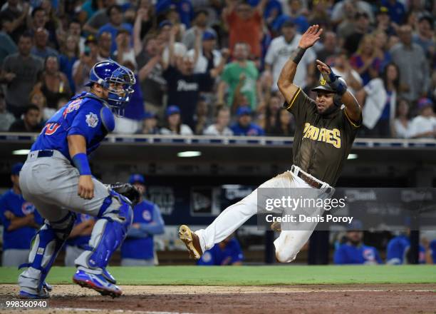 Manuel Margot of the San Diego Padres scores ahead of the throw to Willson Contreras of the Chicago Cubs during the eighth inning of a baseball game...