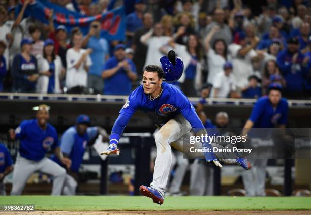 Javier Baez of the Chicago Cubs dives as he scores during the tenth inning of a baseball game against the San Diego Padres at PETCO Park on July 13,...