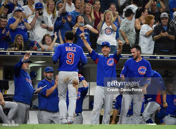 Javier Baez of the Chicago Cubs is congratulated after scoring during the tenth inning of a baseball game against the San Diego Padres at PETCO Park...