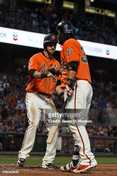 Steven Duggar of the San Francisco Giants is congratulated by Brandon Crawford after scoring a run on a balk by Edwin Jackson of the Oakland...