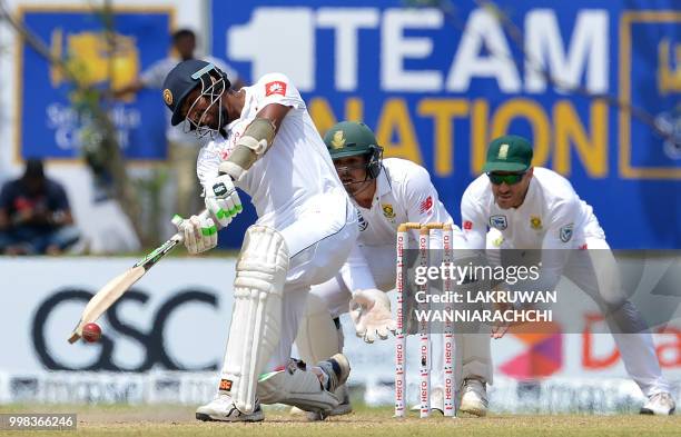 Sri Lanka's Suranga Lakmal plays a shot in front of South Africa's wicketkeeper Quinton de Kock and Faf du PLessis during the third day of the...