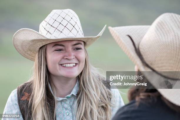 fröhlich lächelnd in richtung freund cowgirl - johnny greig stock-fotos und bilder