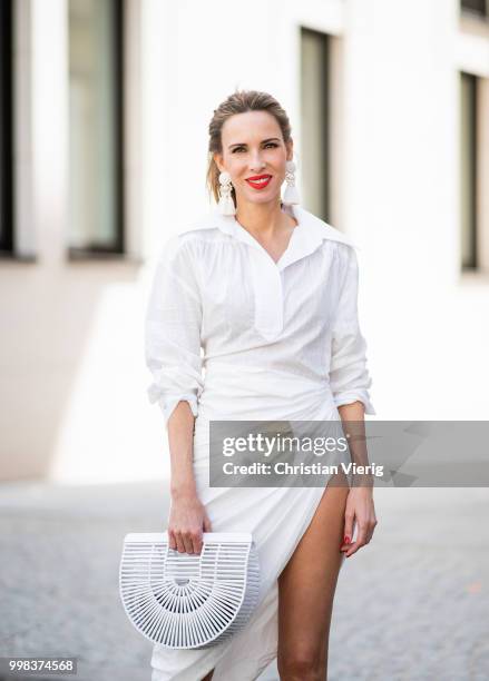 Alexandra Lapp is seen wearing La robe Amadora dress in white by Jacquemus, white Inez leather sandals by Saint Laurent, white Gaia's Ark bag by Cult...