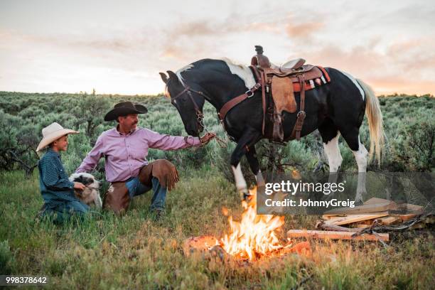 vaquero padre e hijo a caballo de fogata - johnny greig fotografías e imágenes de stock