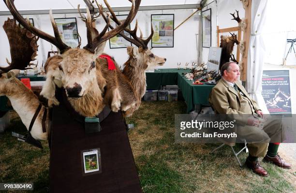 Man sits at the entrance of a country pursuits stall during the final day of the 160th Great Yorkshire Show on July 12, 2018 in Harrogate, England....