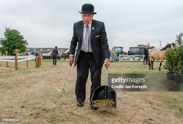 Steward scoops up horse droppings during the final day of the 160th Great Yorkshire Show on July 12, 2018 in Harrogate, England. First held in 1838...