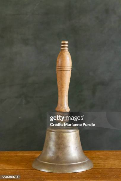 a hand-held school bell - campana de mano fotografías e imágenes de stock