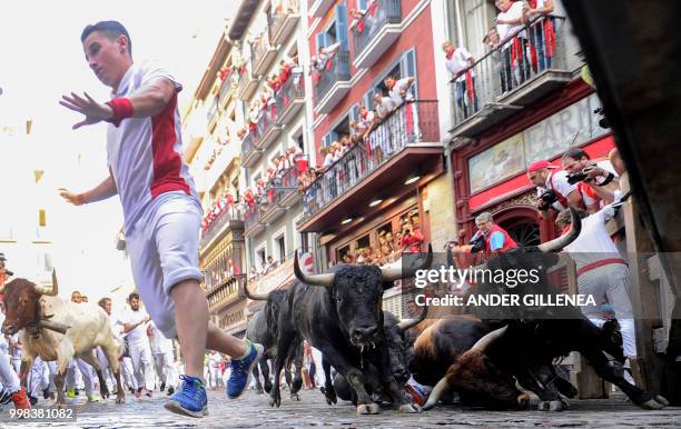 Miura fighting bulls fall on the last bullrun of the San Fermin festival in Pamplona, northern Spain on July 14, 2018. - Each day at 8am hundreds of...