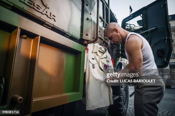 Soldier of the 3rd Marine Artillery Regiment prepares his uniform for the annual Bastille Day military parade on the Champs-Elysees avenue in Paris...