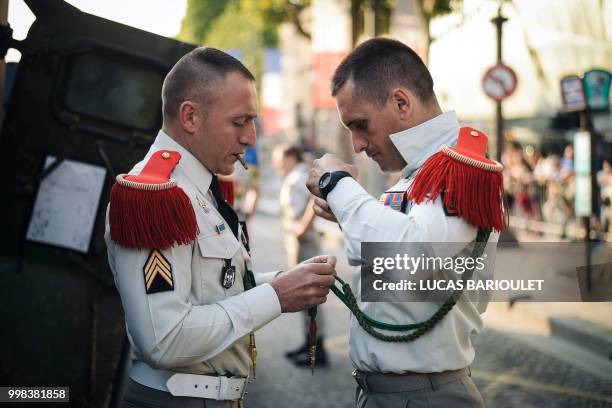 Soldiers of the 3rd Marine Artillery Regiment prepare their uniforms for the annual Bastille Day military parade on the Champs-Elysees avenue in...