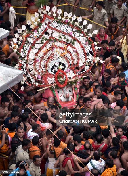 Devotees throng around the icon of Balabhadra, brother of the Hindu deity Jagannath, is brought out from the Jagannath temple during the annual Hindu...