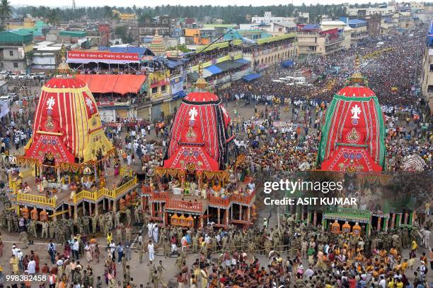 Devotees gather around chariots as they wait to pull them during the annual Hindu festival Rath Yatra or chariot procession in Puri on July 14, 2018....