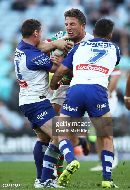 Sam Burgess of the Rabbitohs is tackled during the round 18 NRL match between the Canterbury Bulldogs and the South Sydney Rabbitohs at ANZ Stadium...