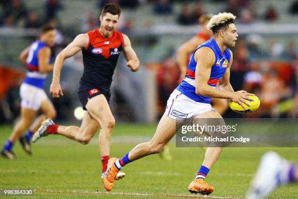 Jason Johannisen of the Bulldogs runs with the ball in his 100th match during the round 17 AFL match between the Melbourne Demons and the Western...