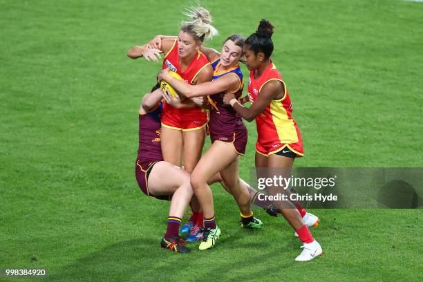 Paige Parker of the Suns is tackled during the AFLW Winter Series match between the Gold Coast Suns and the Brisbane Lions at Metricon Stadium on...