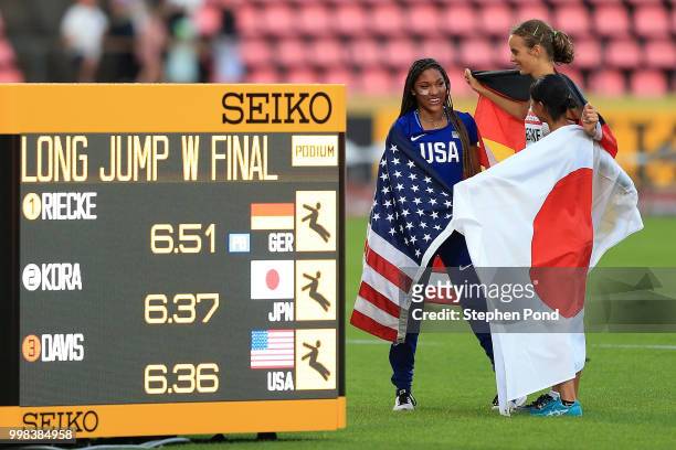 Tara Davis of The USA, Lea-Jasmin Riecke of Germany and Ayaka Kora of Japan celebrate after winning medals in the final of the women's long jump on...