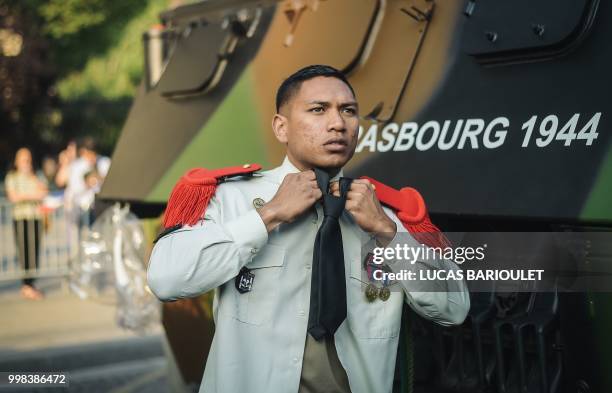 Soldier of the 3rd Marine Artillery Regiment adjusts his tie for the annual Bastille Day military parade on the Champs-Elysees avenue in Paris on...