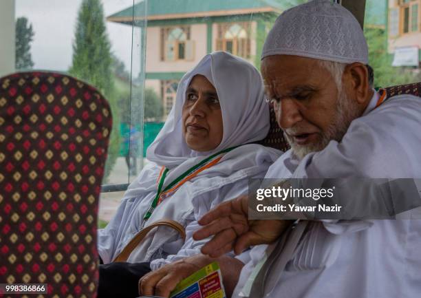 An elderly kashmir Muslim Hajj pilgrim looks at his wrist watch as their bus departs for the annual Hajj pilgrimage to Mecca on July 14, 2018 in...