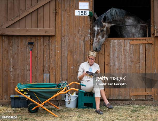 Woman sits outside a stable as a horse sniffs her head during the final day of the 160th Great Yorkshire Show on July 12, 2018 in Harrogate, England....