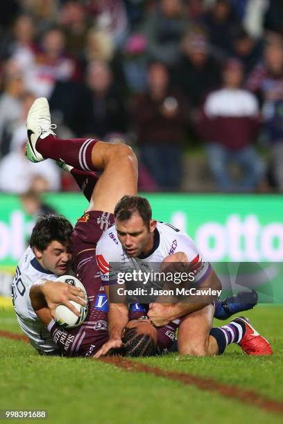 Martin Taupau of the Sea Eagles is tackled by Cameron Smith of the Storm during the round 18 NRL match between the Manly Sea Eagles and the Melbourne...