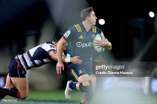 Josh McKay of the Highlanders is tackled during the round 19 Super Rugby match between the Highlanders and the Rebels at Forsyth Barr Stadium on July...