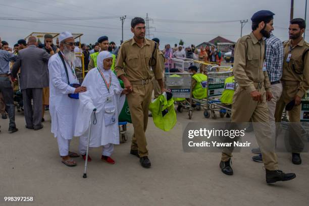 Saja Begum walks with her son Mohammad Saleem 60, as they walk to board a bus before departing for the annual Hajj pilgrimage to Mecca on July 14,...