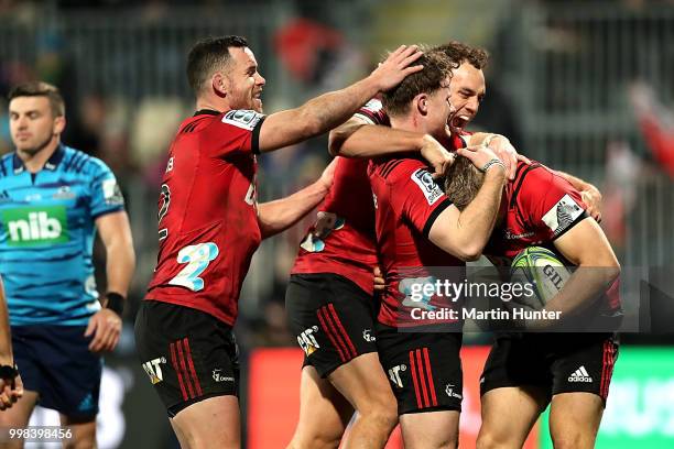 Ryan Crotty, Israel Dagg, Mitchell Drummond and Jack Goodhue all of the Crusaders celebrate after scoring a try during the round 19 Super Rugby match...