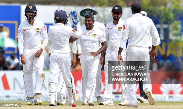 Sri Lanka's Rangana Herath celebrates with his teammates after he dismissed South Africa's Dale Steyn during the third day of the opening Test match...