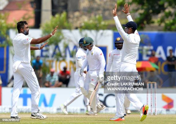 Sri Lanka's Dilruwan Perera celebrates with his teammates after he dismissed South Africa's Quinton de Kock during the third day of the opening Test...