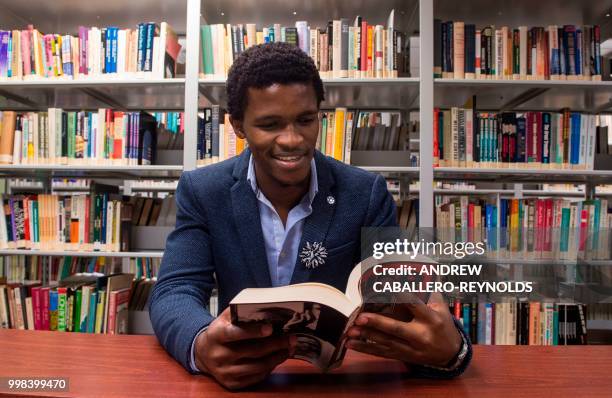 Siyabulela Mandela, grandson of Nelson Mandela, poses during a photo session in a library at George Mason University before an interview with AFP in...