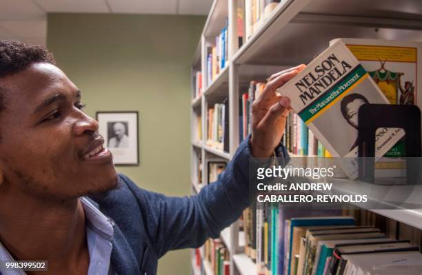 Siyabulela Mandela, grandson of Nelson Mandela, poses during a photo session in a library at George Mason University before an interview with AFP in...