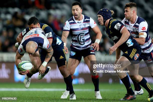 Billy Meakes of the Rebels is tackled by Lima Sopoaga of the Highlanders as Michael Ruru of the Rebels and James Lentjes of the Highlanders look on...