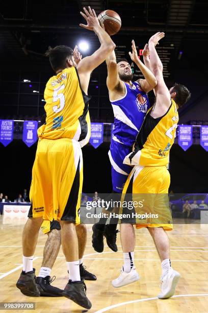 Jordan Mills of the Saints shoots under pressure from Xavier Shaw and Thane O'Leary of the Mountainairs during the NZNBL match between Wellington...