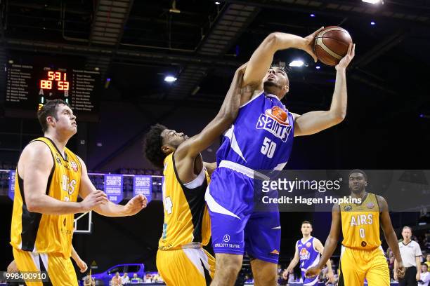 Shane Temara of the Saints gathers a rebound under pressure from Alonzo Burton of the Mountainairs during the NZNBL match between Wellington Saints...
