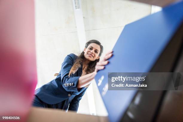 businesswoman taking a file out of a box in the office - box file stock pictures, royalty-free photos & images