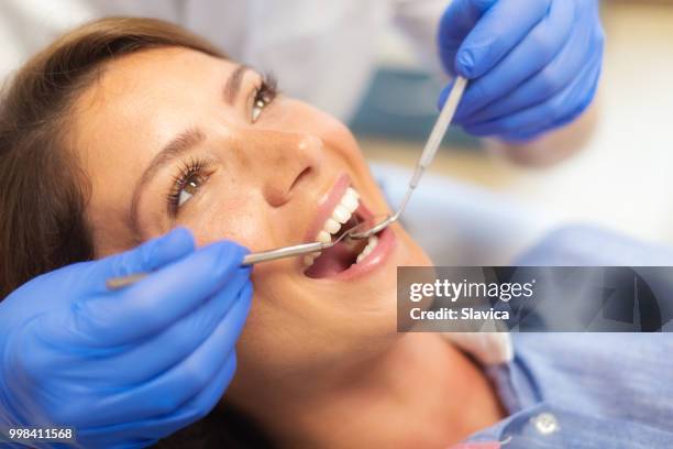 zahnärztin examinining patienten zähne - religiöses ereignis stock-fotos und bilder