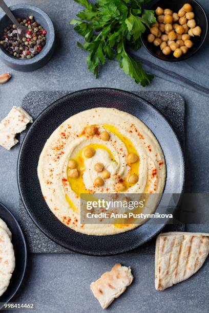 hummus, chickpea dip, with spices and pita, flat bread in a black plate. top view - flat top stock pictures, royalty-free photos & images