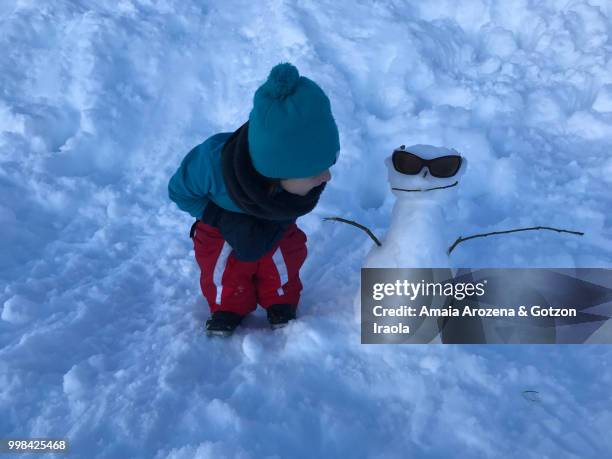 little girl and snowman - amaia - fotografias e filmes do acervo