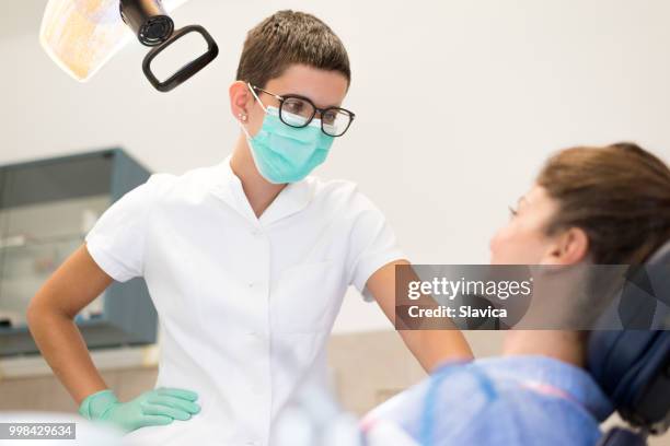 zahnarzt im gespräch mit patienten - religiöses ereignis stock-fotos und bilder