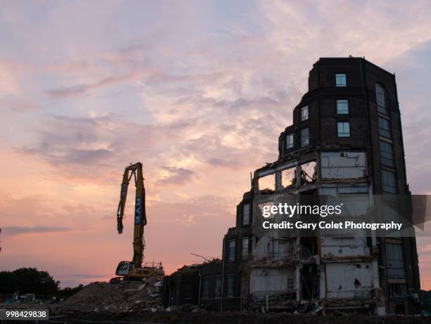 partly demolished large building and construction equipment at sunset - gary colet stock pictures, royalty-free photos & images