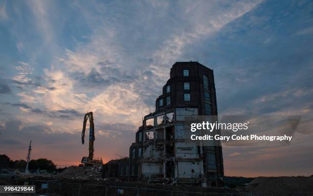 partly demolished large building and construction equipment at sunset - gary colet - fotografias e filmes do acervo